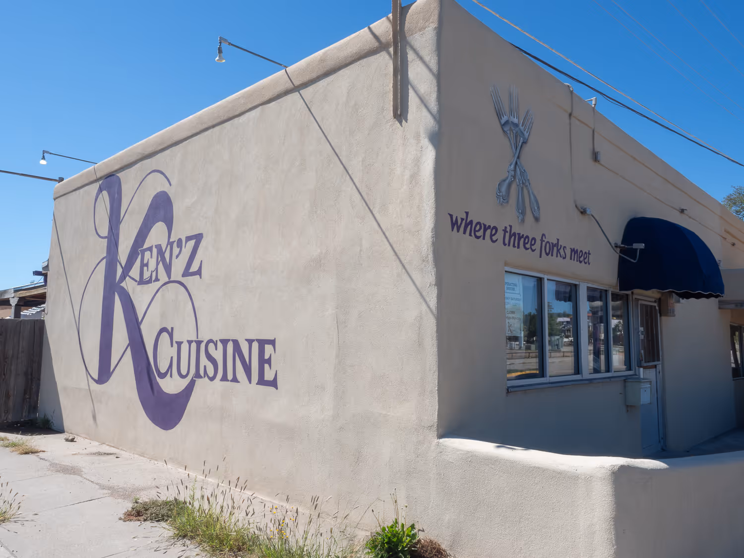 Stucco building with the purple Ken'z Cuisine logo and crossed forks over "where three forks meet"